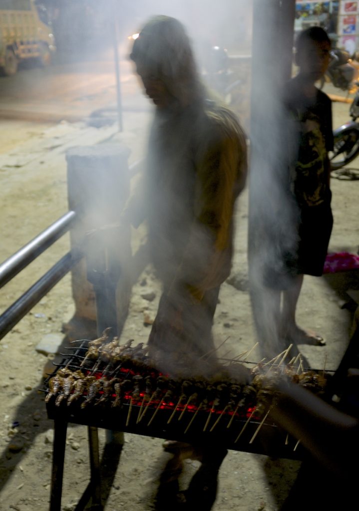 A man grills chicken in the remote town of Aileu, East Timor. Many Timorese families do not eat meat regularly at home, but it is served on special occasions at cultural ceremonies.