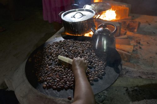A Maya woman roasts cacao beans grown on her family’s farm in southern Belize. The family traditionally drinks cacao unsweetened but flavored with allspice.
