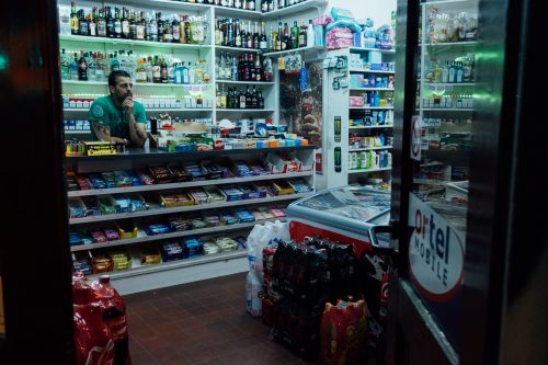 An Indian employee stands behind the counter of a night shop in Antwerp’s famous Jewish quarter. Along with a typical selection of food and drinks, the shop owners sell homemade samosas in a small tray on the counter.