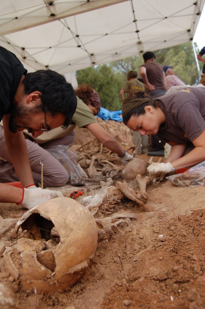 Archaeologists excavating human remains.