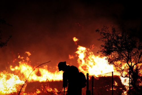 Inmate firefighters - An inmate firefighter cuts a line around the edge of a nighttime burn. Prison fire crews live at their prison complex, but they are released during the day to work on fire-related projects. They are also on call 24/7, and correctional officers have the ability to take the crew off the prison grounds anytime there is a fire. Some wildfires may require the crew to stay out of prison for two or three weeks at a time. Fires have their own terms and sentences that are much more unpredictable than the highly structured day-to-day experience of incarceration.