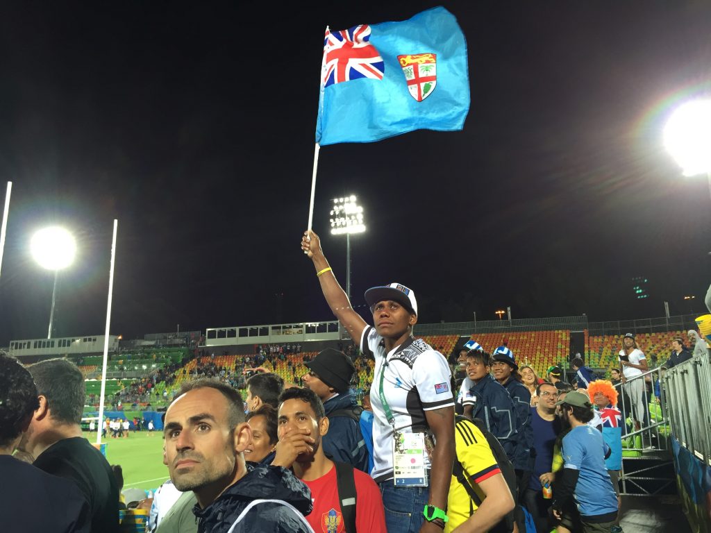Fiji rugby - A teary-eyed member of Fiji’s women’s rugby team raised the Fijian flag after the men’s rugby team won the Olympic gold medal. Viewers watched on a big-screen TV as team captain, Osea Kolinisau, kissed his wife—a public display of intimacy unusual in Fiji that seemed to move the fans.