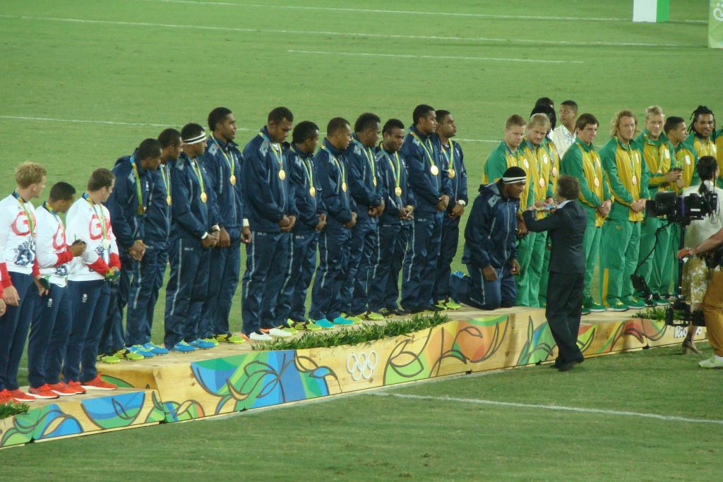 As International Olympic Committee member Princess Anne draped a gold medal around a Fijian player’s neck, he knelt as a sign of respect.