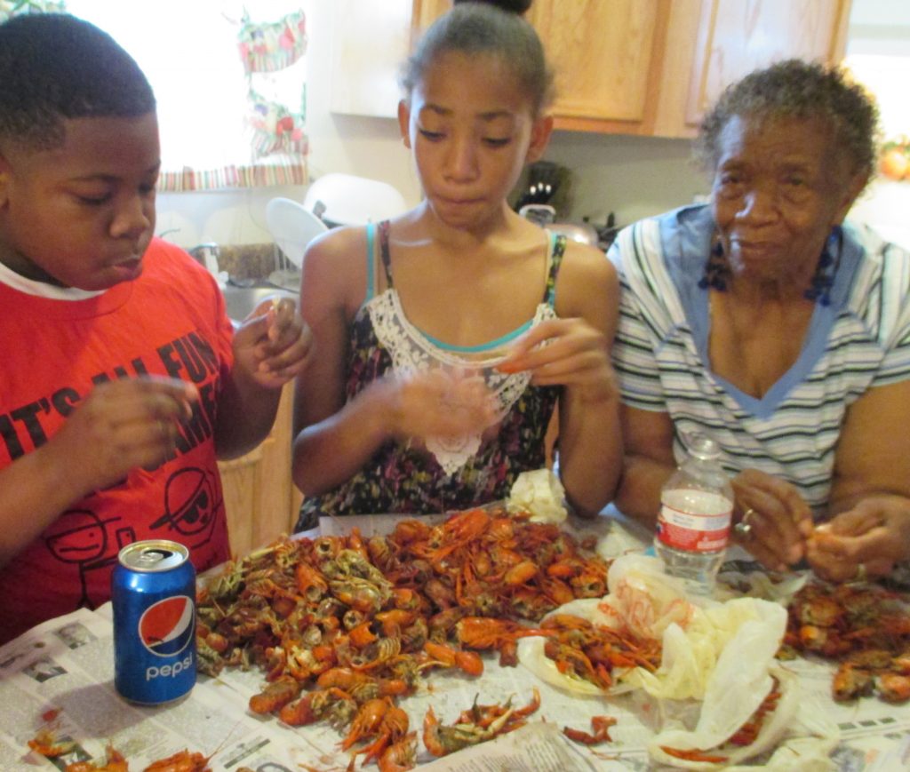 Hurricane Katrina aftermath - Sharing a good crawfish snack across generations reinforces a sense of family identity and connection to the bayou’s abundance.
