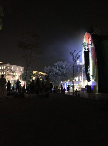 Olympic festival -- Spectators are silhouetted against the light of the big-screen television on Praça Mauá