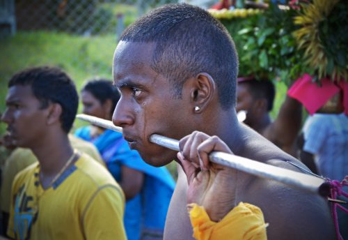 A Mauritian man carries a large rod pierced through his cheeks during the Thaipusam Kavadi Festival. Such extreme rituals may demonstrate a person’s genuine commitment to a group. According to costly signaling theory, such acts of loyalty signal trustworthiness, resulting in higher levels of cooperation among group members. When my colleagues and I studied this festival, we found that intense ordeals can make the community more altruistic.