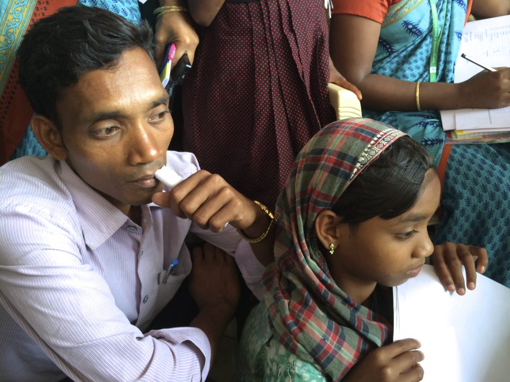 A man and girl sit together with anxious expressions.