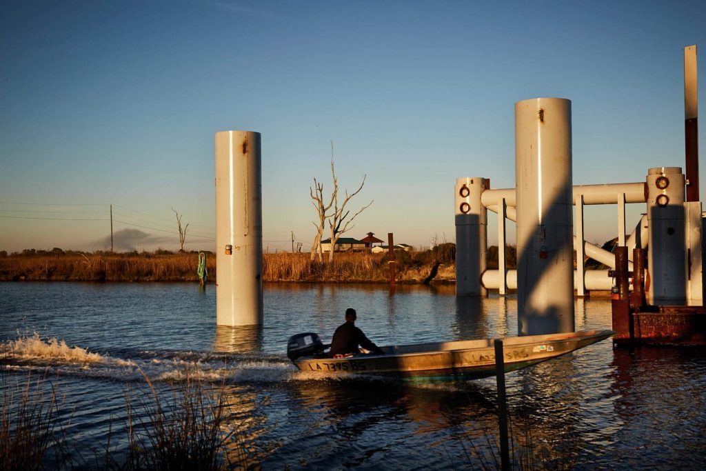 A boater passes a floodgate under construction in Bayou Pointe-au-Chien, Louisiana.