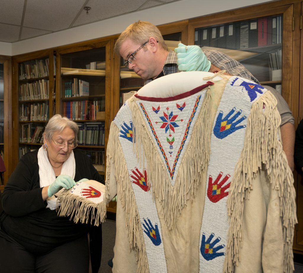 Stella Iron Cloud and the author, Steve Nash, inspect the Many Hands shirt on November 29, 2013.