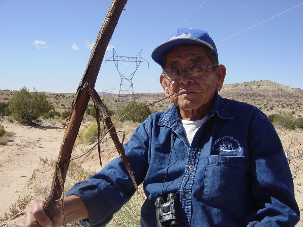 Hopi elder Owen Numkena holds a juniper root, used to make traditional bows for hunting and ceremonies.