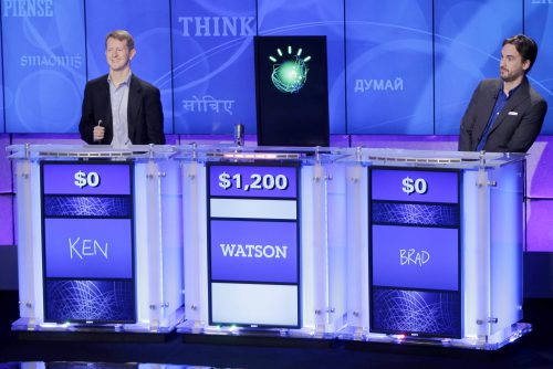 game theory anthropology - Jeopardy! champions Ken Jennings, left, and Brad Rutter, right, look on as the IBM computer Watson beats them to the buzzer to answer a question during a practice round of the quiz show in Yorktown Heights, New York.