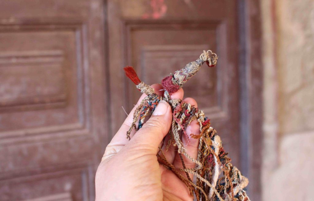 The needlework bundles, called caytes, at the beginning of the khipus indicate the khipu's subject matter. The brilliant red brush is made from deer hair and is believed to signify “warfare.”