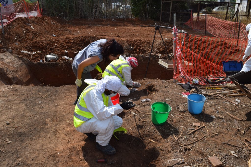 People dig at a site.