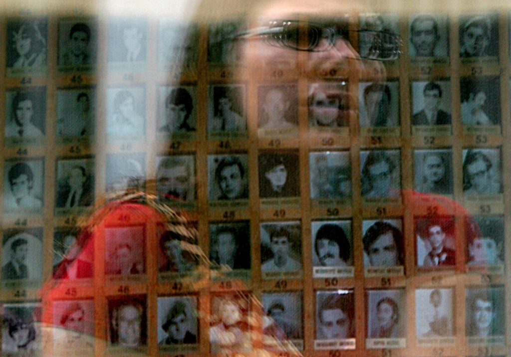 A woman studies an array of photographs.
