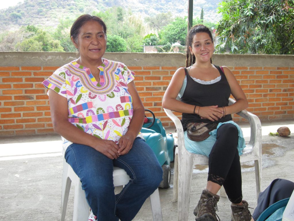 Yanira opens her home to numerous international apprentices who observe, learn, and offer a helping hand. She is shown here sitting with an apprentice from Spain.