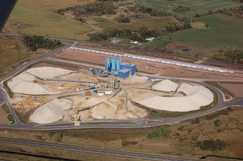 Frac sand mining brings with it heavy industrial activity. Four separate railroad transload stations have been permitted in Dovre. Sand is trucked to the rail load-outs from area mines, though at least one company in the adjacent town of Sioux Creek has plans to build a conveyor system. The operation pictured here in October 2013 is now owned by Northern White Sand, which is part of Eagle Materials.