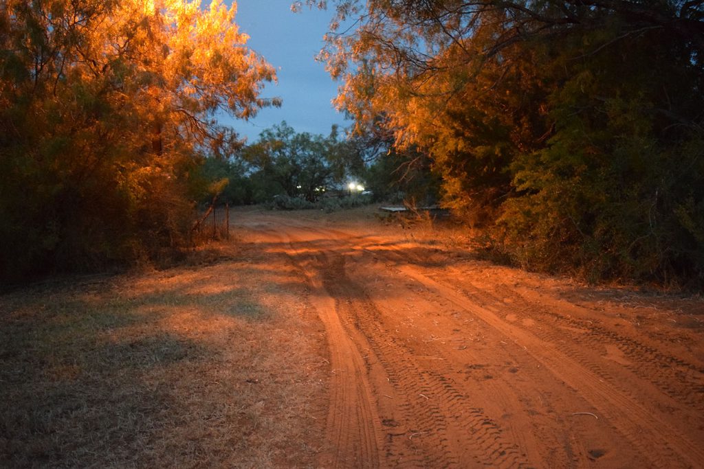 Ever present, the glow of the massive floodlights of the Dilley detention center reaches to the residence of the legal aid staff.