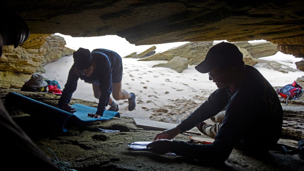 Charles Helm, right, and his wife, Linda, work in the cave on the South African coast where they found ancient footprints.
