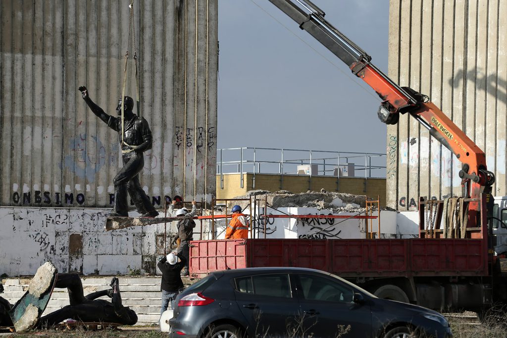 Crews dismantle a monument honoring Onésimo Redondo, one of the founders of the fascist Falange de las JONS party, in 2016. Although Article 15 of the 2007 Law of Historical Memory mandates that all such public monuments commemorating the fascist dictatorship should be removed, implementation has been uneven.