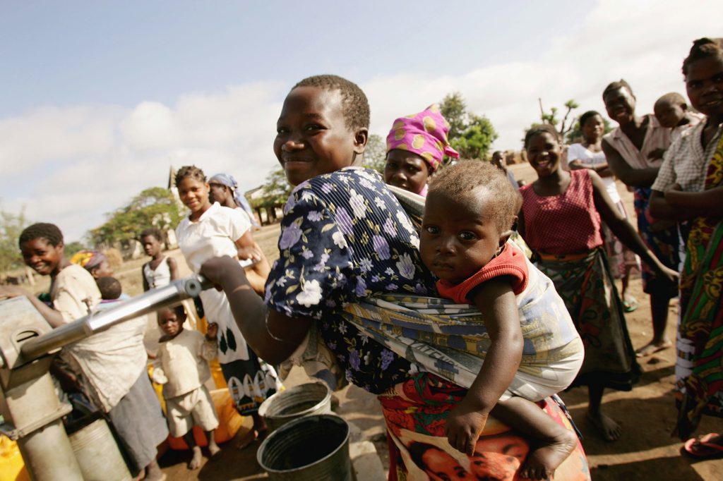 People collect water from a pump in a small village in Mozambique.