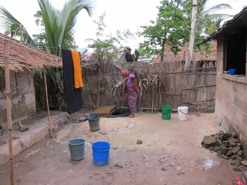 A woman in Nampula City, Mozambique, fetches water at a neighbor's well.