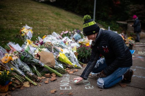 A mourner writes “Enough Is Enough” at a memorial near the Tree of Life Synagogue on Monday, October 29, in Pittsburgh, Pennsylvania.