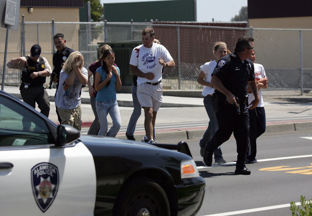 trigger warnings - A police officer evacuates students who volunteered to take part in a school shooting and mass evacuation drill at Lincoln Middle School in Alameda, California. The participants wore makeup to simulate injuries.