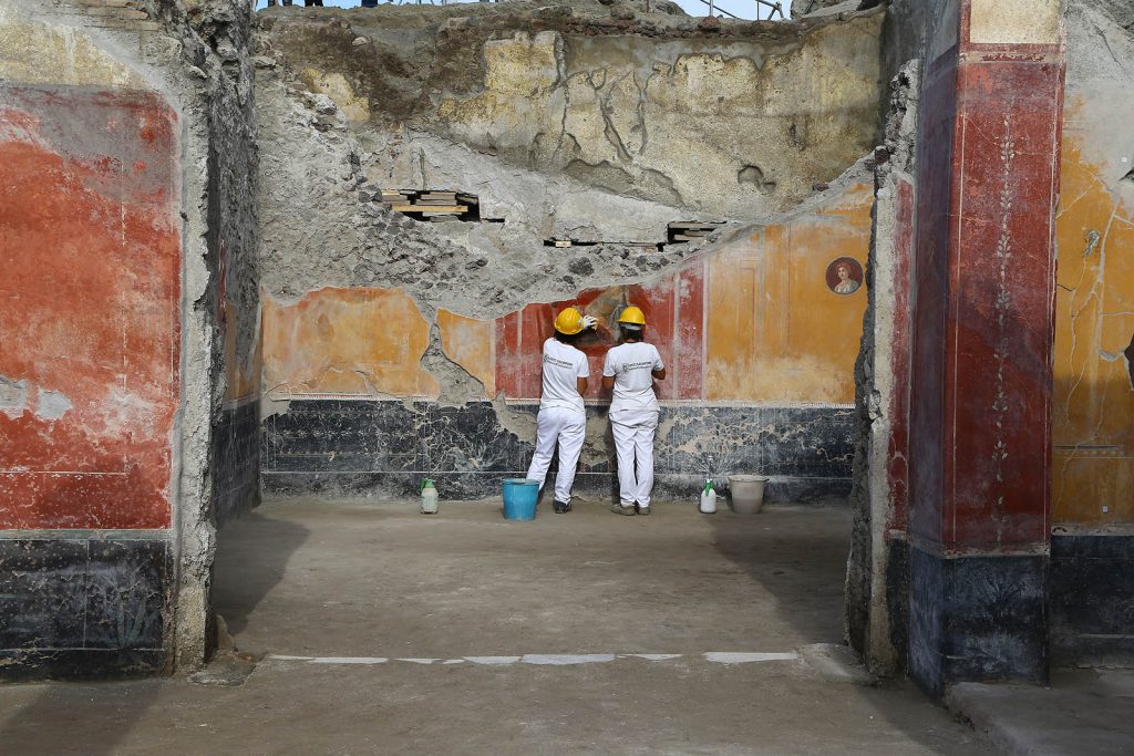 Restorers work on a fresco in a newly excavated area of Pompeii, the ancient Roman town buried by the eruption of Vesuvius in A.D. 79.