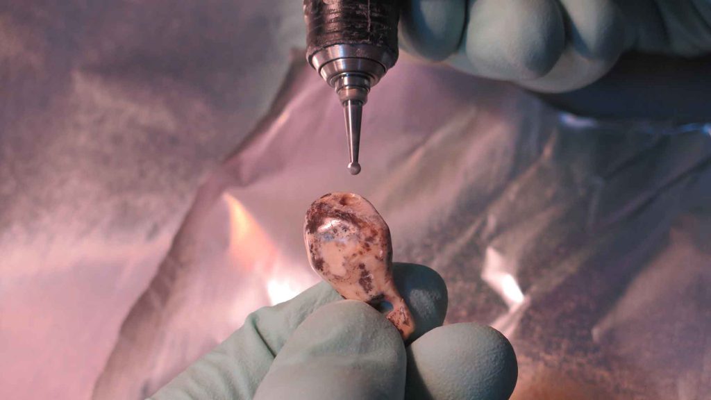 Tooth pendants (one pictured here), along with other artifacts discovered at Denisova Cave, mark the earliest evidence of human ornamentation—between 43,000 and 49,000 years ago—in northern Eurasia.