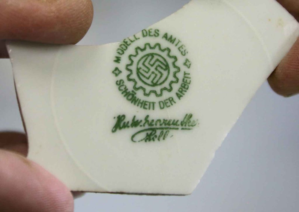 A plate fragment excavated at the former Tempelhof Airport in Berlin displays the phrase Schönheit der Arbeit, “Beauty of Work,” which is the name of a Nazi propaganda organization for workplace efficiency.