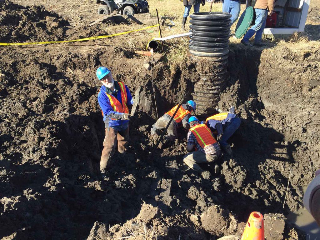 Fisher (far left) excavates on farmer Jim Bristle’s land in Michigan in 2017.