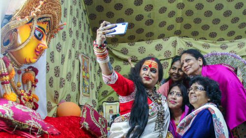 Laxmi Narayan Tripathi, high priestess of a convent of hijras, takes selfies with admirers at India’s 2019 Kumbh Mela religious festival.