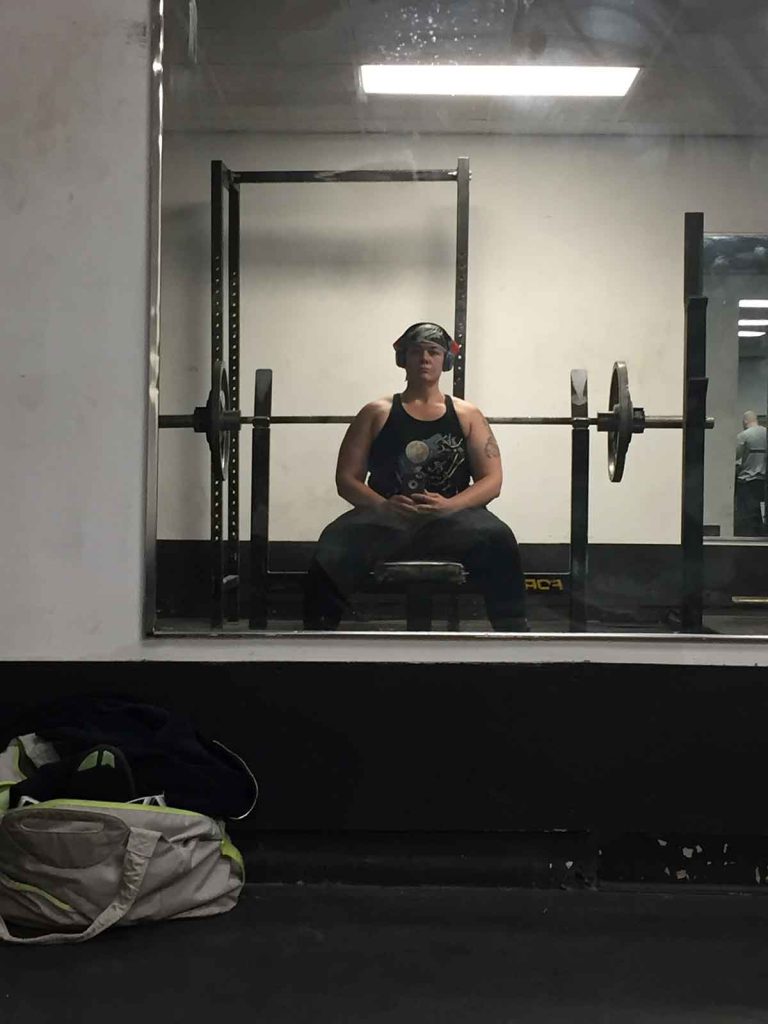 Ready to bench press, the author arms herself with her “fuck-off” headphones to fend off unwanted comments.
