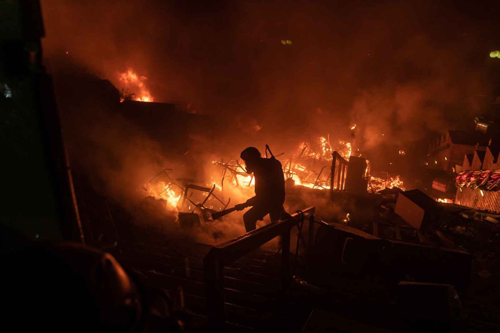 Harmony - In November 2019, a protester tries to put out a fire at The Hong Kong Polytechnic University, where protesters armed with bricks, firebombs, and bows and arrows were calling for an independent inquiry into police brutality, among other demands.