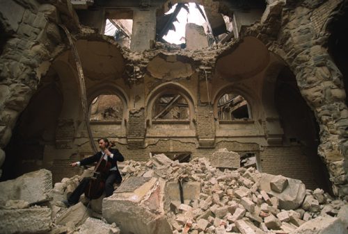 Bosnian cellist Vedran Smailovic plays an elegy in Sarajevo’s blasted and burned library.