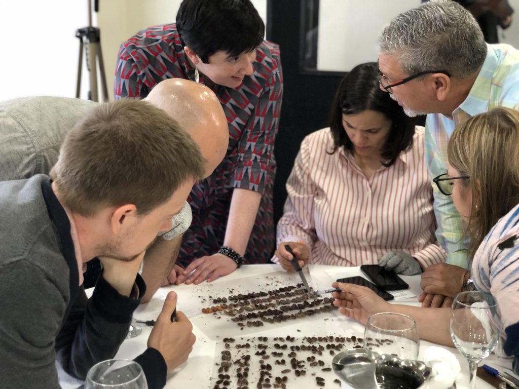 During a workshop in the Dominican Republic, Martin (center left) talks to a group of students about how to grade cacao.