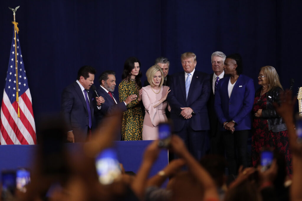 President Trump stands with other leaders in prayer.