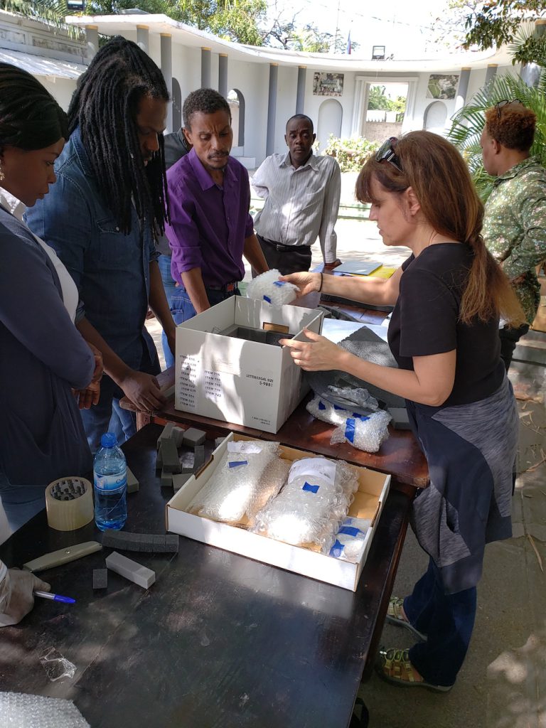 Anthropologist Holly Cusack-McVeigh (second from the left) unpacks objects for a repatriation ceremony at the Haitian Bureau of Ethnology Museum in Port-au-Prince, Haiti.