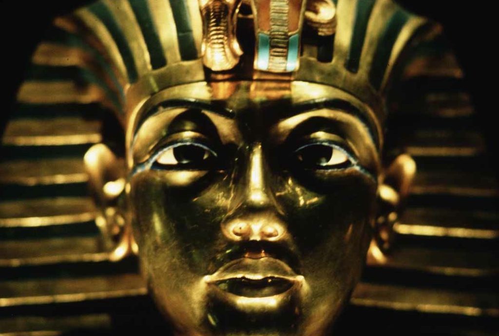 A photo shows a gold mask of an Egyptian king on display at a museum.