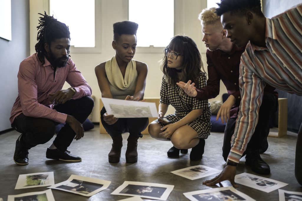 anthropology image representation - Business team discussing some papers on the floor in the office