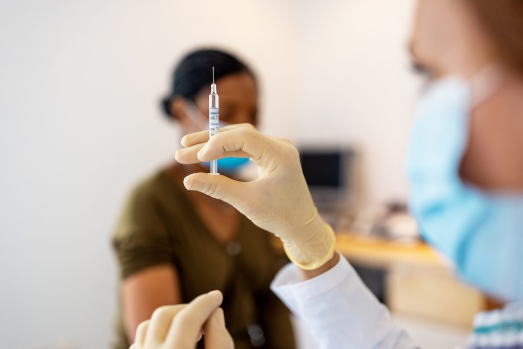 vaccines anthropology - Close up of doctor preparing injection for vaccination in clinic. Hands of a female doctor preparing flu injection.