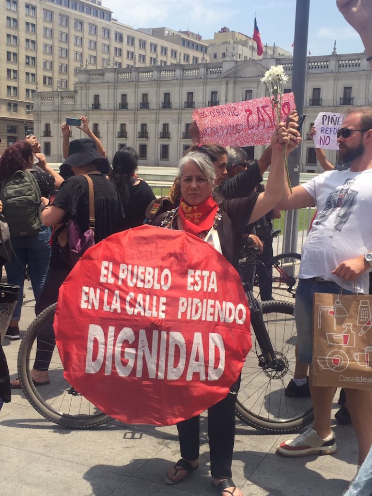 Chile democracy dignity - A demonstrator holds a sign that says, “The people are in the street asking for dignity.”
