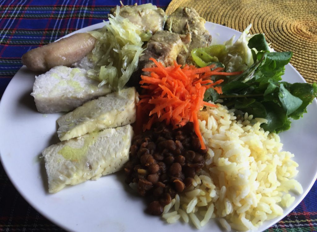 A colorful plate of fish, rice, vegetables, and tubers.