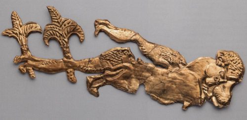 A golden decoration features an animal set upon by lions on three sides.