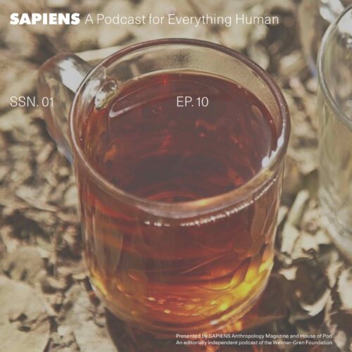 A glass of steaming tea sits on a marble table.