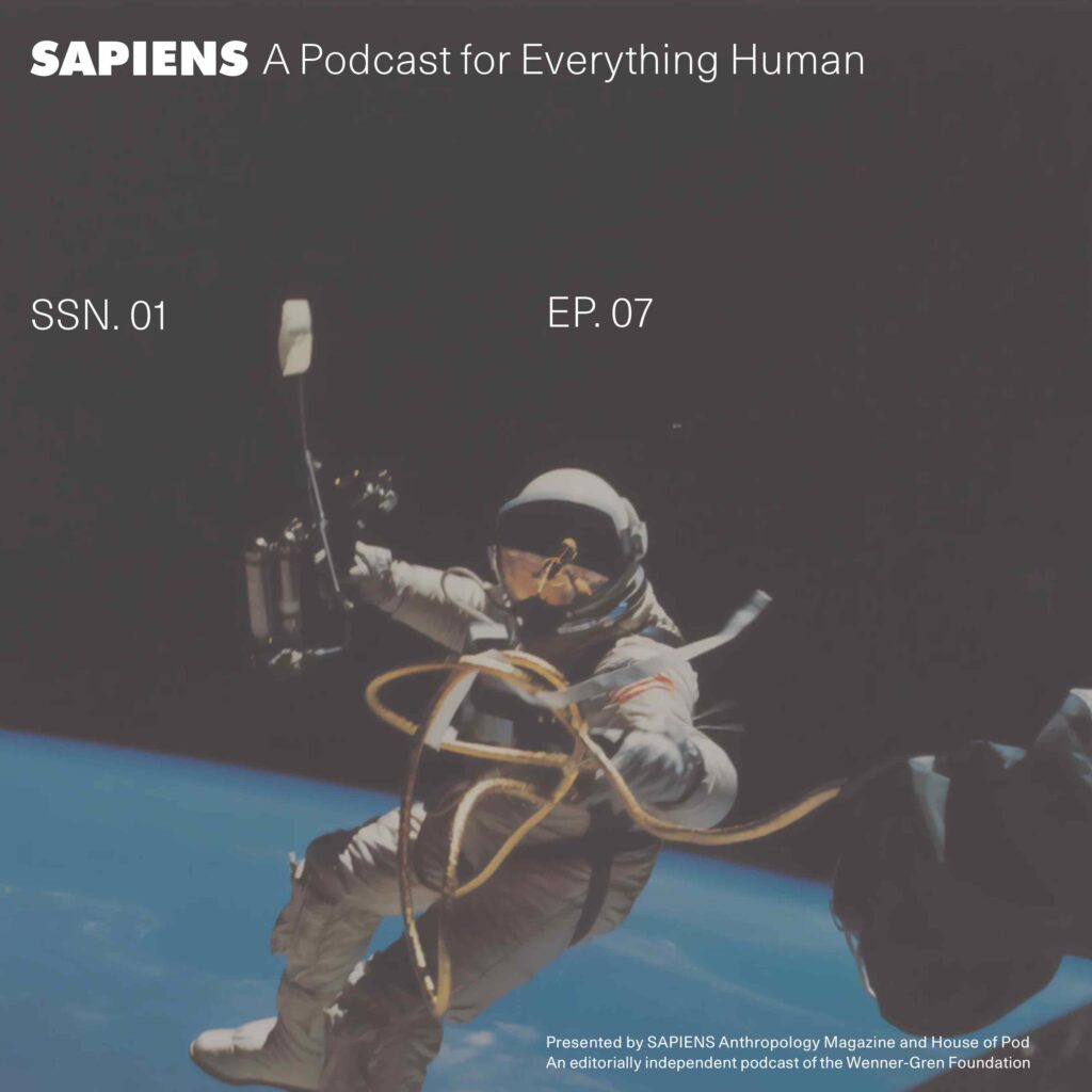 An astronaut floats in space on a spacewalk holding various equipment.