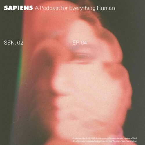 A red, blurry human face set against a black backdrop.