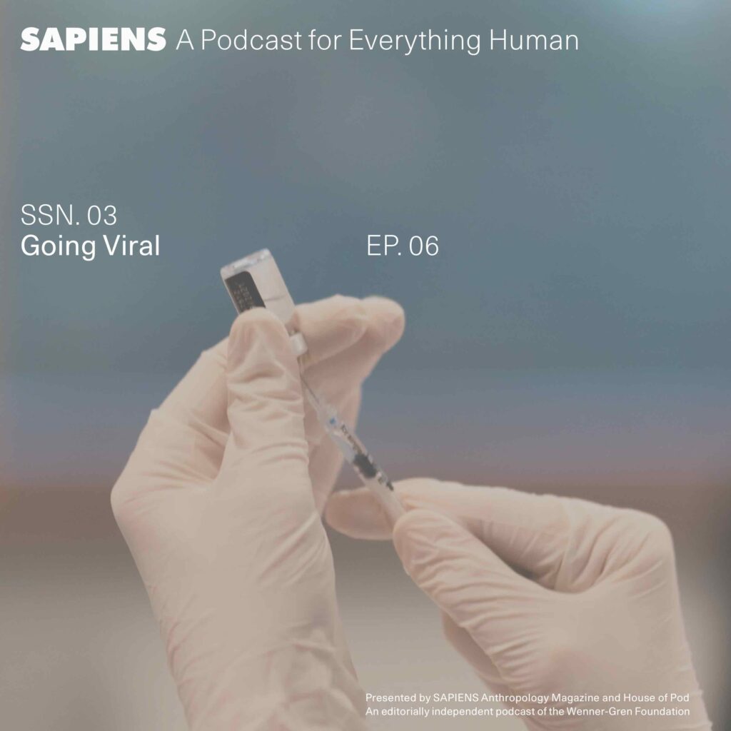 Two hands in medical gloves prepare a shot, with a needle and vial.