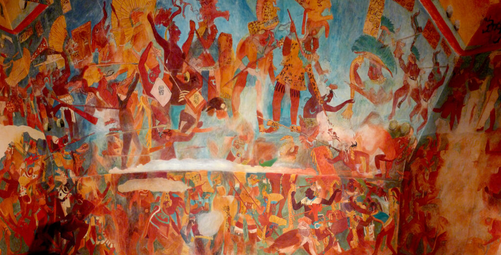 A large mural depicts a chaotic battle with numerous people, either shirtless or wearing animal skins, yelling while holding up spears or their fists.