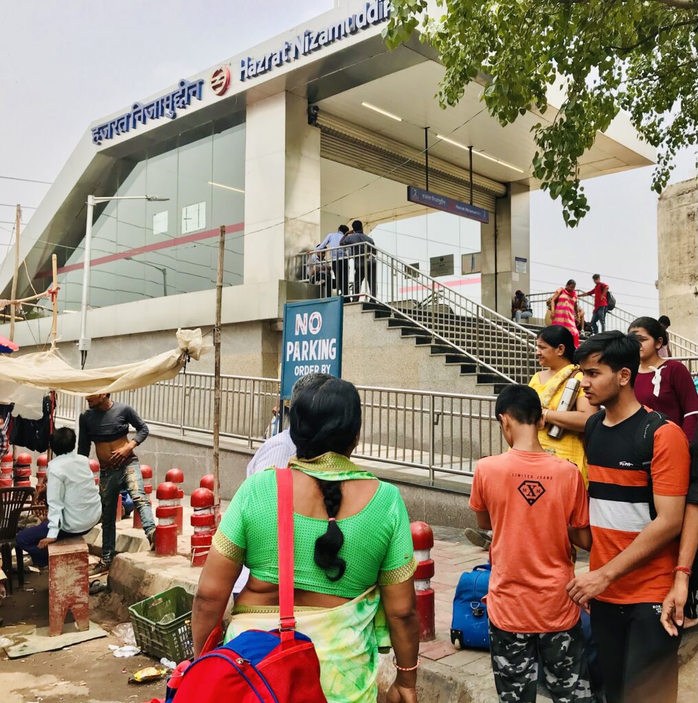 A photograph features people waiting in line on a staircase that leads to a cement structure.